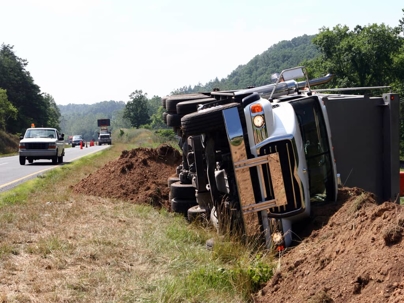 a truck tipped over on the side of the road
